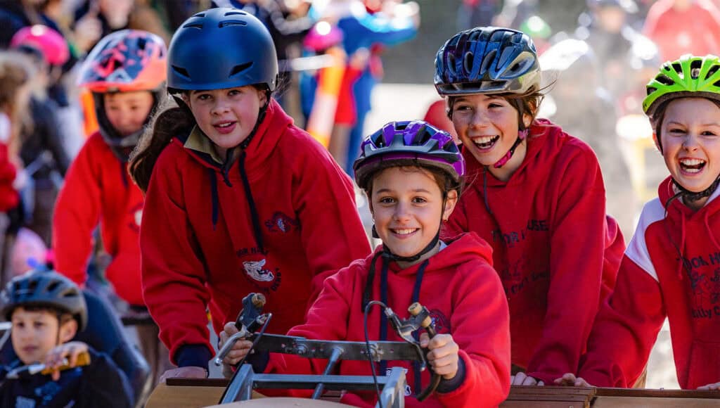 Girls pushing a billy cart smiling