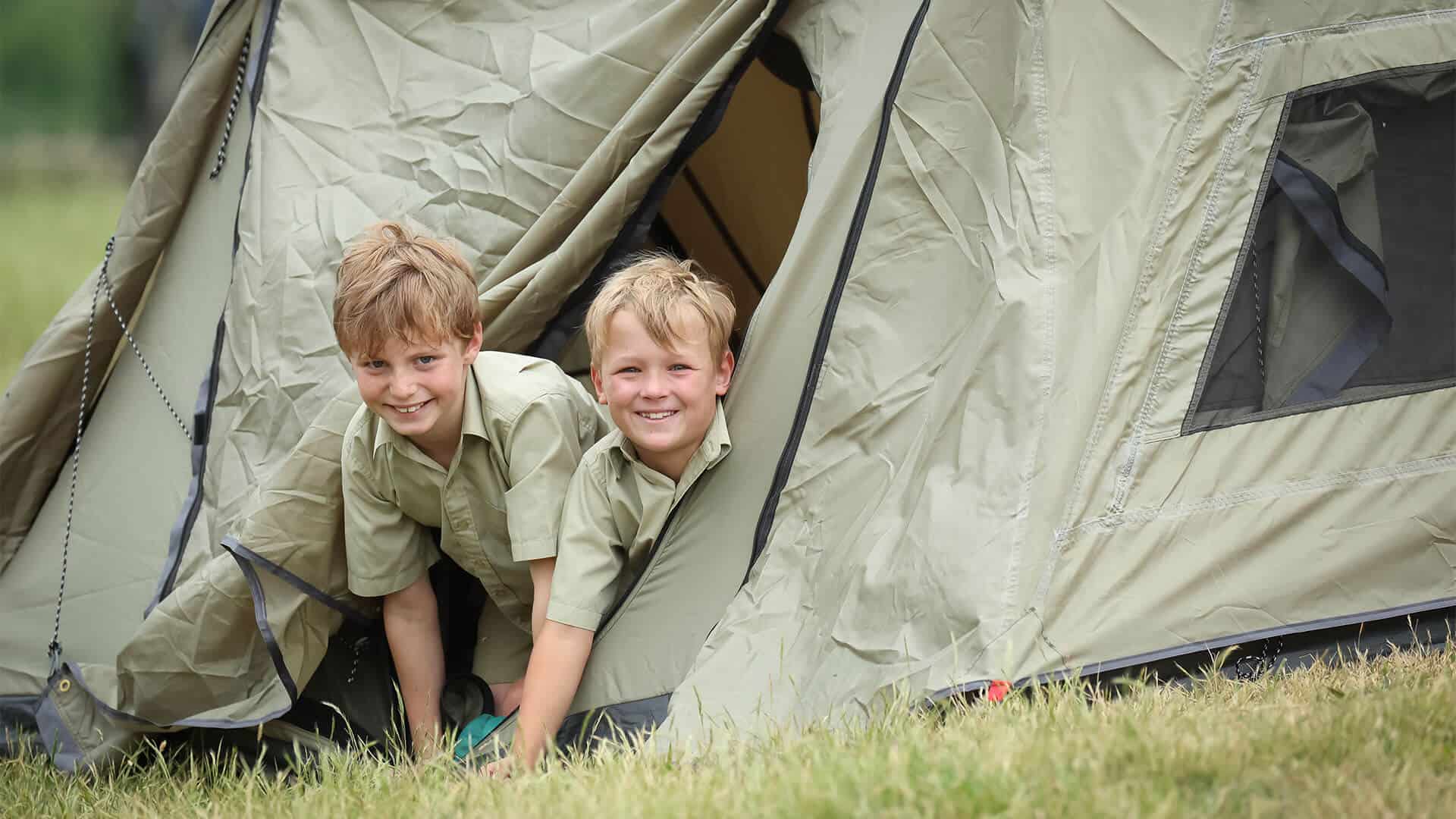 Tudor House students sticking their heads out of a tent