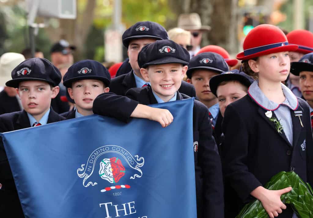 Tudor House students holding a banner and wreath