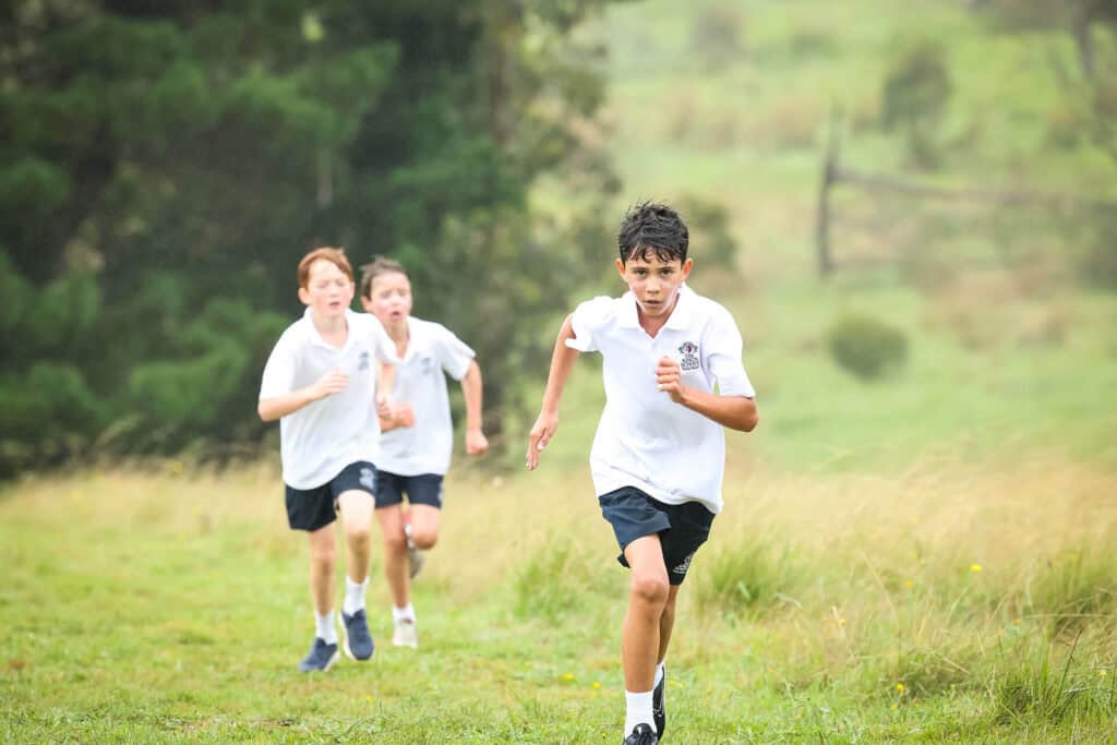 Tudor House students running through the grass for cross country