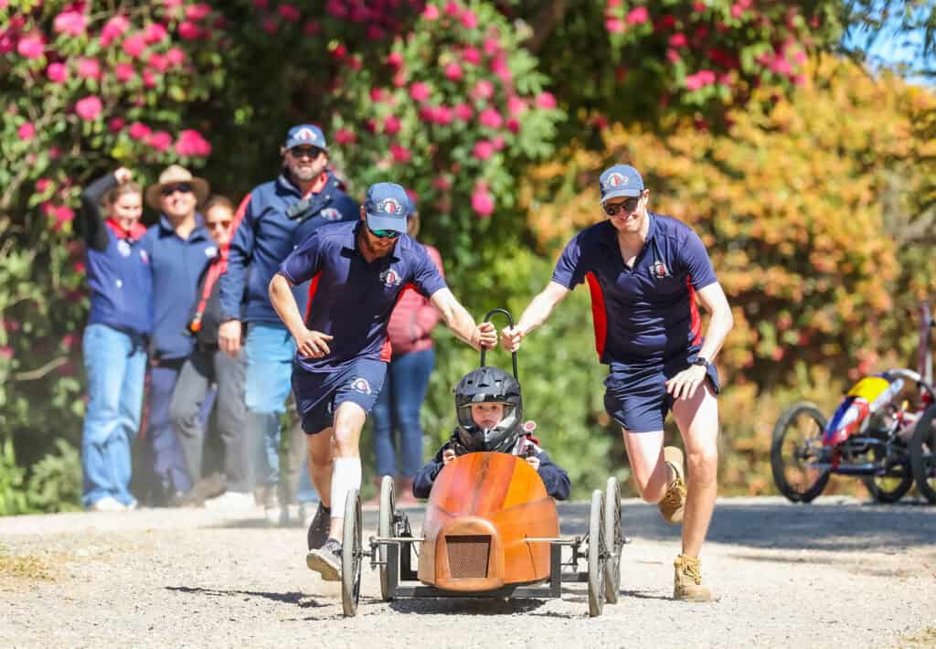 Tudor House staff pushing a billy cart and running
