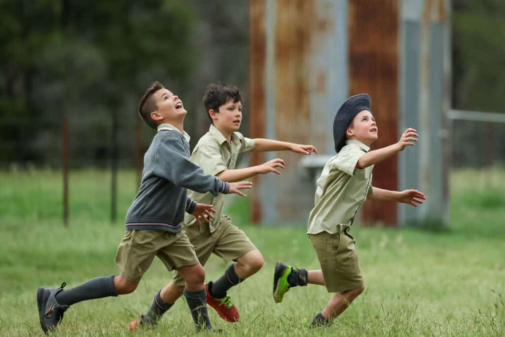 Tudor House students running looking up through grass